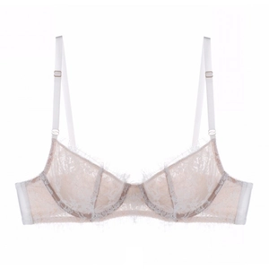Dettaglio macro di delicato pizzo francese a ciglia su un reggiseno crema sottile