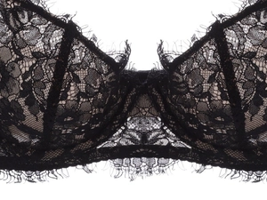 Dettaglio del pizzo floreale nero e delle ciglia sulla coppa del reggiseno sottile