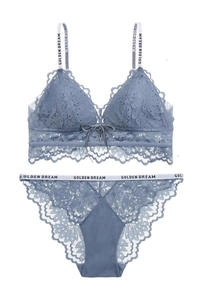 Dettagli di un set di lingerie in pizzo grigio-blu con motivi floreali e spalline logate