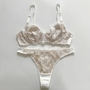 Detailed flat lay of white eyelash lace lingerie set with semi-transparent floral patterns