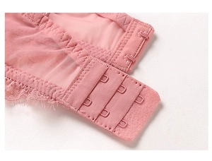 Detailed close-up of pink lace bra back closure with three-row hook-and-eye design