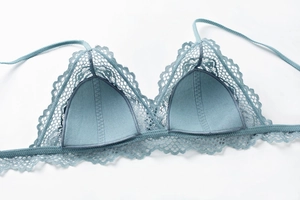 Gros plan détaillé d'une bralette en dentelle bleu-gris avec motifs floraux et bonnets