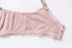 Detail view of pink lace bra wings with breathable mesh and three-row hook fastener