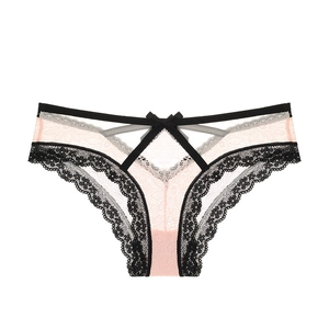 Détail de maille rose clair et dentelle florale noire avec lanières en V et noeud