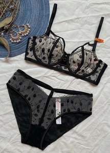 Dettaglio del ricamo floreale su un set reggiseno e slip in mesh bianco e nero morbido