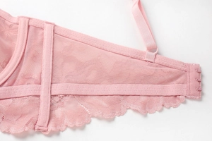 Detailed close-up of pink lace bra side wings with breathable mesh and three-row back hooks