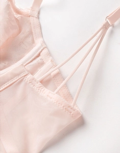 Détail de dentelle florale rose clair et bretelles triples sur un soutien-gorge mesh