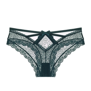 Détail de culotte en dentelle vert foncé avec motifs floraux et décoration de nœud