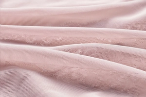Detail of light pink fine mesh fabric with honeycomb structure for breathable lingerie