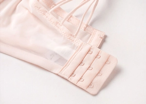 Détail du soutien-gorge en dentelle rose pâle avec fermeture à trois rangées d'agrafes