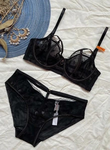 Vista dettagliata del set lingerie in pizzo nero con ricamo floreale e etichetta della taglia