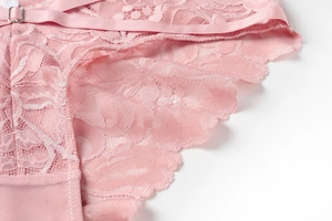 Makrodetail aus rosa Blumenstickerei-Spitze und verstellbarer Metallschnalle am Dessous-Set