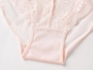 Gros plan sur la broderie florale en dentelle rose clair et la doublure en coton doux