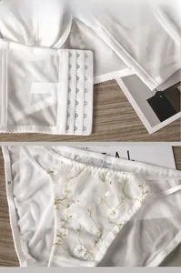 Detail view of white lace bra with seven-row hook-and-eye closure and floral embroidery