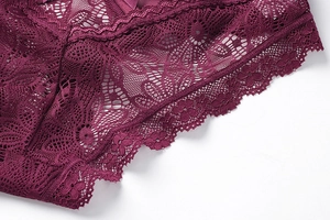 Gros plan d'une culotte en dentelle rouge foncé avec broderie florale et nœud en satin