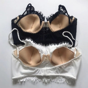 Detailed flat lay of black and white lace bralettes with delicate eyelash lace edges