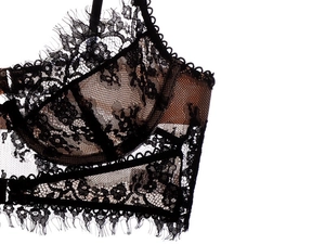Detailed close-up of French eyelash lace and mesh fabric on a black underwire bra