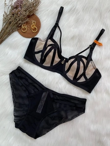 Detailed flat lay of a black lace lingerie set with geometric mesh and size tag 75B