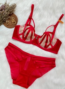 Flat lay of red lace lingerie set with underwire bra and strappy panties on white rug