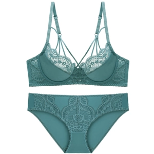 Flat lay of a deep teal lace lingerie set featuring intricate floral embroidery and straps