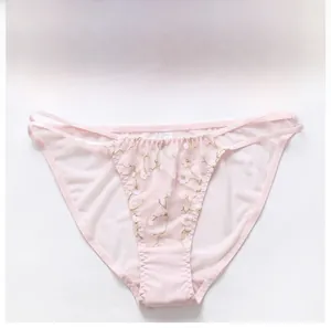 Détail d'une culotte en dentelle rose clair avec broderie florale et fines brides