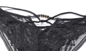 Détail de lingerie en dentelle florale noire avec anneaux dorés et sangles croisées