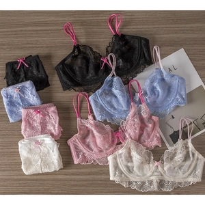Flachbild-Detail von Spitzenunterwäsche-Sets in Schwarz, Violett, Rosa und Weiß auf Holzgrund