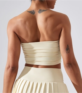 Detailansicht des Rückens vom cremefarbenen Tube Top und dem plissierten Tennisrock-Set