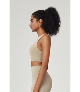 Detailed side view of beige asymmetric athletic top and high-waisted yoga leggings