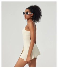 Vue latérale de la robe de tennis beige avec découpe à la taille et tissu extensible mat