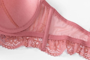 Gros plan du soutien-gorge en dentelle rose montrant broderies et détails en maille