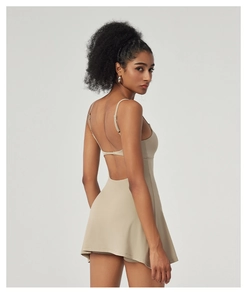 Détail du dos nu de la robe de sport à fines bretelles et ourlet plissé beige clair