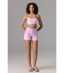 Vue détaillée de la brassière de sport rose à fines bretelles et du short à cordon