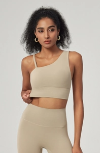 Detail view of asymmetric straps on a khaki sports bra with matte seamless yoga fabric