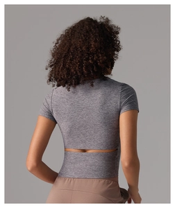 Haut de yoga court gris ajusté avec découpe horizontale au dos et tissu respirant élastique