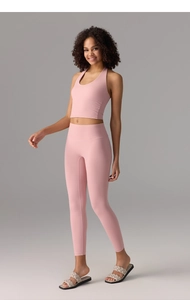 Detail of light pink halter yoga sports bra and high-waisted leggings set in soft fabric