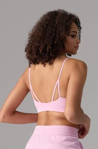 Détail de la brassière de sport rose avec bretelles fines et design dos croisé triple