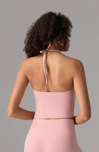 Detail of light pink halter yoga tank top with backless design and elastic fabric
