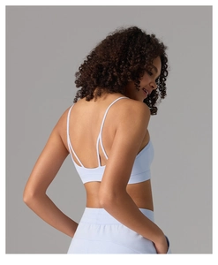 Détail de la brassière de yoga bleu clair sans couture avec fines bretelles et dos nu