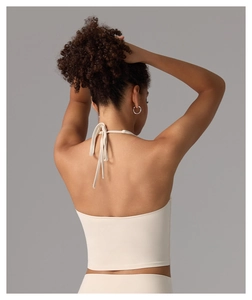 Rear view of cream halter yoga top featuring a deep open back and criss-cross tie details