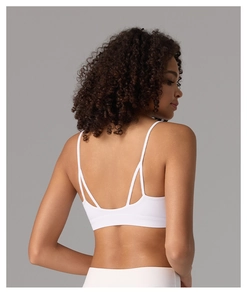 Détail du soutien-gorge de sport blanc montrant les fines bretelles croisées dans le dos