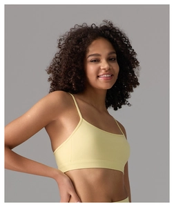 Détail de la brassière de yoga jaune clair avec fines bretelles et bande de maintien