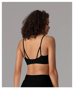 Détail des fines bretelles croisées sur un soutien-gorge de sport noir sans couture