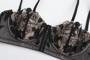 Close-up of rose flower embroidery on semi-transparent black lace mesh bra cups