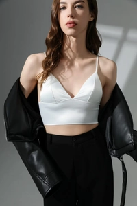 Satin V-neck crop top paired with a black leather jacket and high-waisted trousers