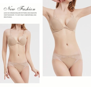 Dettaglio spalline in pizzo floreale e chiusura frontale su set reggiseno beige