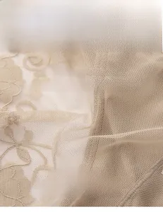 Detailed macro view of sheer beige floral mesh lace fabric with 82% nylon and 18% spandex