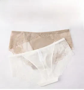 Detailed view of two lace panties in beige and white with sheer floral mesh texture