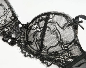 Détail d'un soutien-gorge en dentelle noire avec broderie florale et bretelles satin