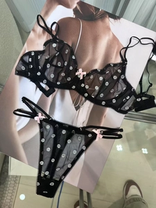 Détail d'un ensemble lingerie en tulle noir à pois blancs et nœuds roses